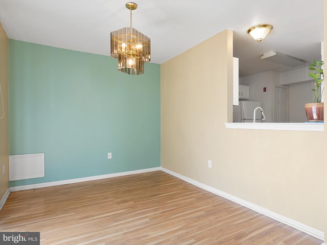 411 Stonebridge Blvd, New Castle, DE 19720 - unfurnished dining area with light wood-style floors, baseboards, and a chandelier