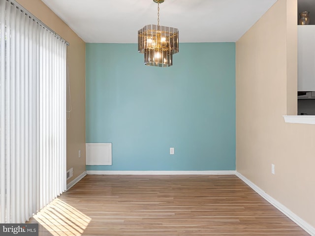 411 Stonebridge Blvd, New Castle, DE 19720 - unfurnished room with a chandelier, wood finished floors, and baseboards