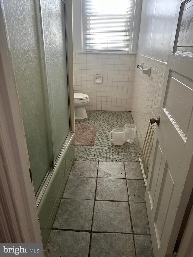 641 N 56th St, Philadelphia, PA 19131 - full bathroom featuring toilet, combined bath / shower with glass door, tile walls, and wainscoting