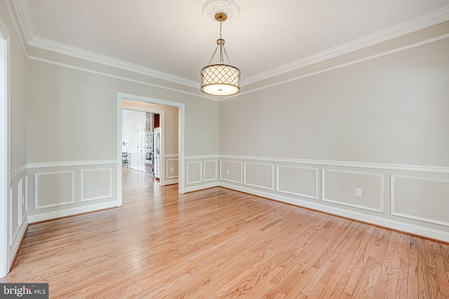 38452 Millstone, Purcellville, VA 20132 - unfurnished room featuring crown molding, light wood finished floors, a decorative wall, and a wainscoted wall