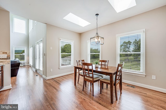 38452 Millstone, Purcellville, VA 20132 - dining space with a skylight, light wood-style flooring, a chandelier, and baseboards