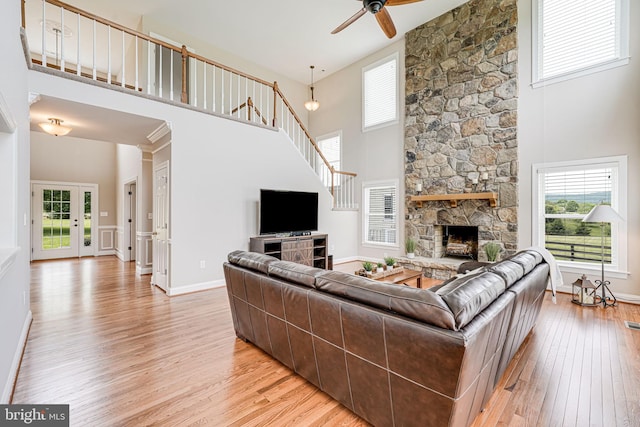 38452 Millstone, Purcellville, VA 20132 - living area with a towering ceiling, a ceiling fan, light wood-style flooring, a fireplace, and stairs