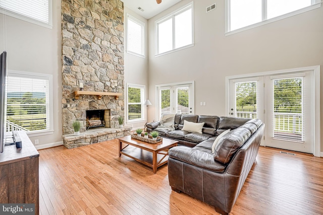 38452 Millstone, Purcellville, VA 20132 - living room featuring light wood finished floors, a high ceiling, a fireplace, and a ceiling fan