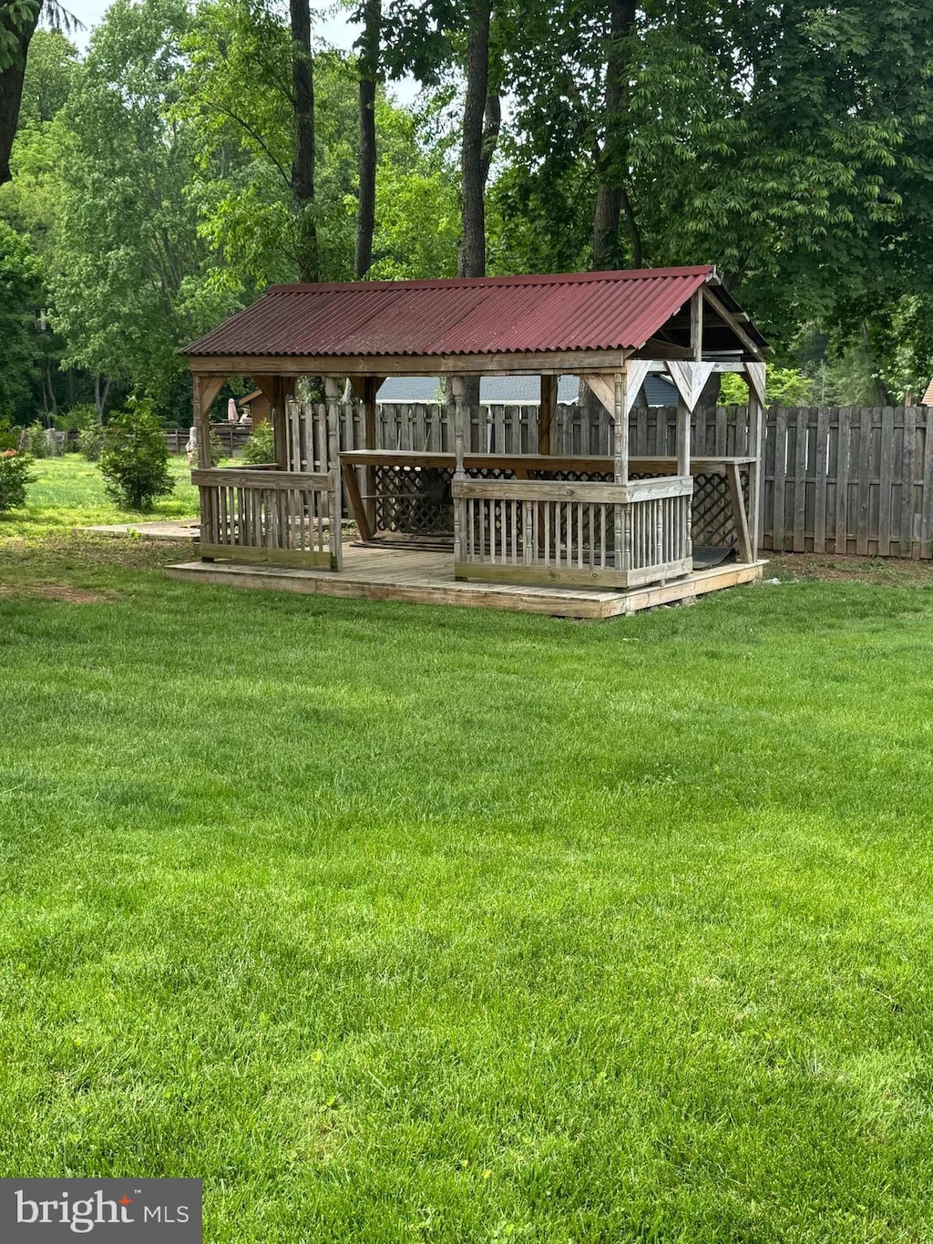 back of property with metal roof and view of wooded area
