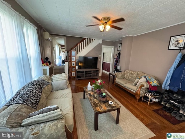 living room with a ceiling fan, wood finished floors, a wall mounted AC, and ornamental molding