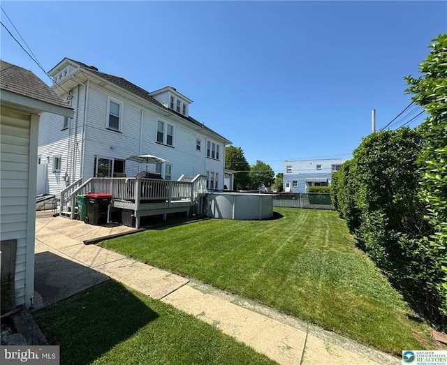 view of grassy yard with a wooden deck