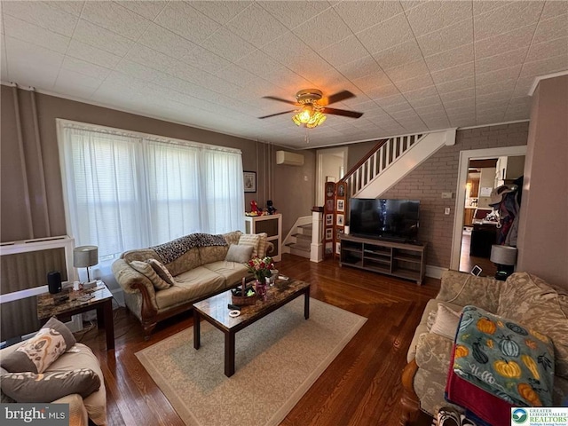 living room with stairs, a wall mounted AC, wood finished floors, and a ceiling fan