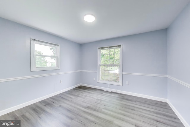 spare room featuring wood finished floors and baseboards