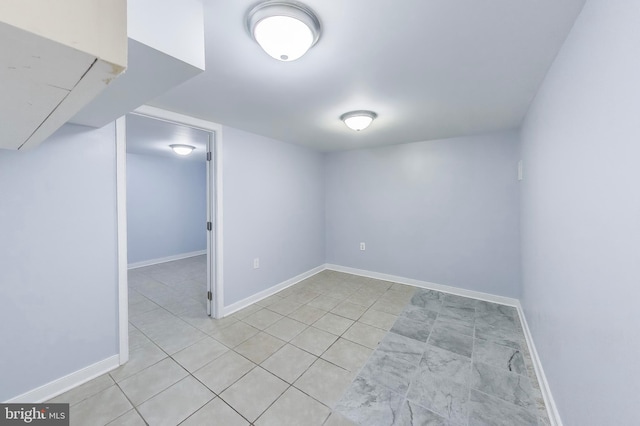 finished basement featuring light tile patterned floors and baseboards