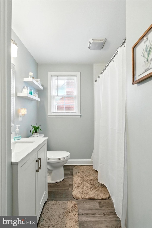 8907 Mavis Ave, Baltimore, MD 21236 - bathroom with wood finished floors, toilet, vanity, baseboards, and a shower with curtain
