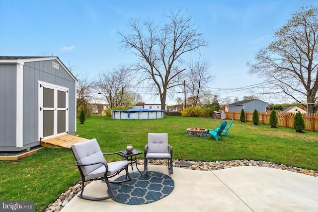 8907 Mavis Ave, Baltimore, MD 21236 - view of yard with a fire pit, a shed, a patio area, an outbuilding, and an outdoor pool