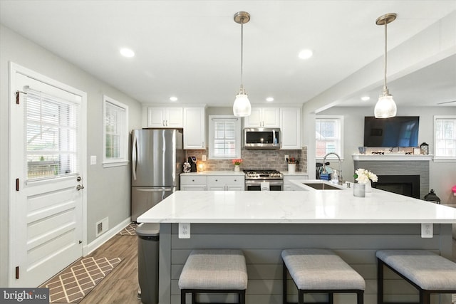 8907 Mavis Ave, Baltimore, MD 21236 - kitchen with appliances with stainless steel finishes, a sink, wood finished floors, white cabinets, and recessed lighting