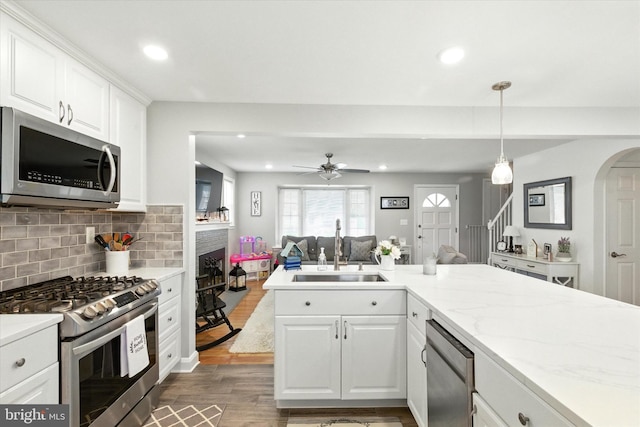 8907 Mavis Ave, Baltimore, MD 21236 - kitchen featuring appliances with stainless steel finishes, a sink, wood finished floors, a brick fireplace, and recessed lighting