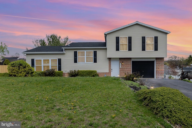 8838 Mckinley Ct, Hummelstown, PA 17036 - tri-level home with driveway, a garage, brick siding, and a front lawn