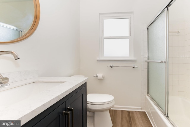 8838 Mckinley Ct, Hummelstown, PA 17036 - bathroom with wood finished floors, toilet, vanity, enclosed tub / shower combo, and baseboards
