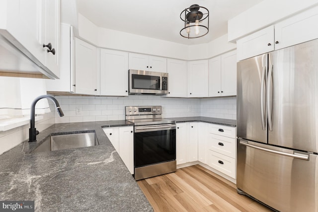 8838 Mckinley Ct, Hummelstown, PA 17036 - kitchen featuring stainless steel appliances, a sink, white cabinets, backsplash, and light wood finished floors