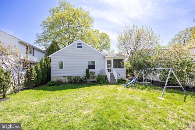 back of house featuring a playground and a sunroom