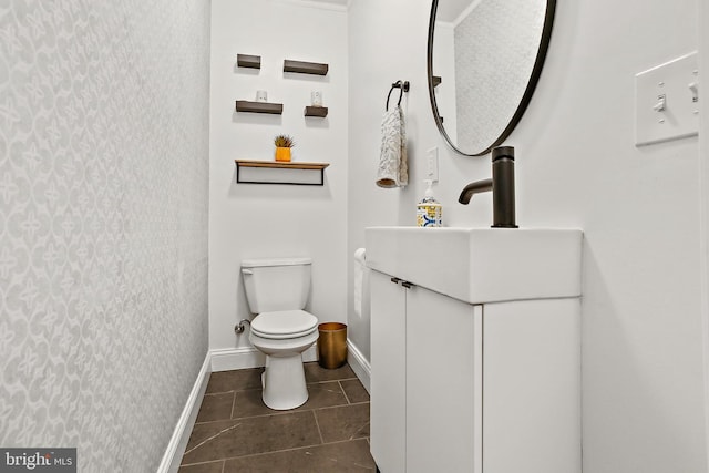 419 S E Ave, Baltimore, MD 21224 - bathroom with wallpapered walls, baseboards, toilet, vanity, and an accent wall