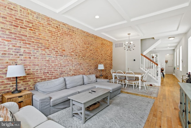 419 S E Ave, Baltimore, MD 21224 - living room with a chandelier, brick wall, coffered ceiling, light wood finished floors, and stairway