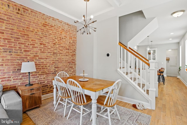 419 S E Ave, Baltimore, MD 21224 - dining space featuring brick wall, light wood finished floors, stairs, baseboards, and a chandelier