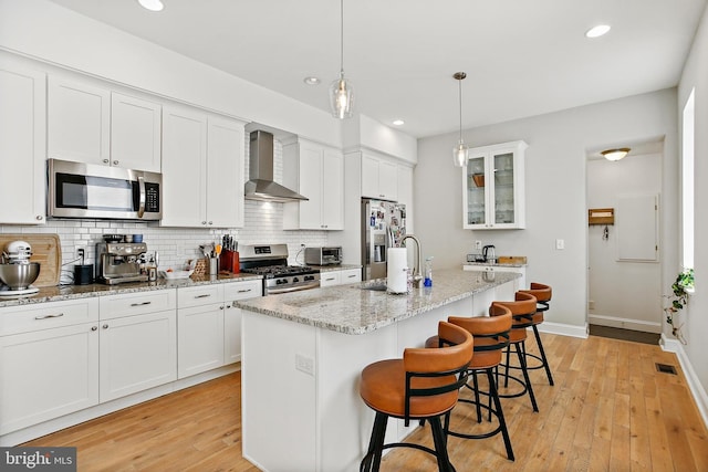 419 S E Ave, Baltimore, MD 21224 - kitchen featuring stainless steel appliances, wall chimney range hood, a sink, backsplash, and a kitchen breakfast bar