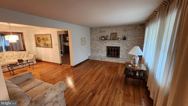 319 Morton Ave, Paulsboro, NJ 08066 - living area featuring hardwood / wood-style floors, a chandelier, a stone fireplace, and baseboards