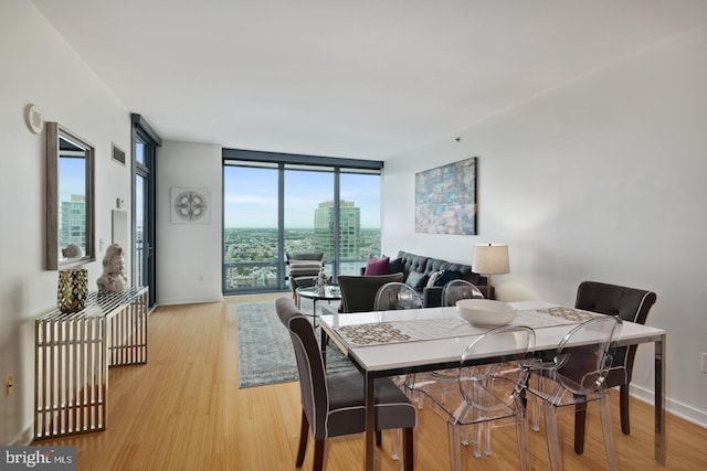 2101 Market St Unit 3405, Philadelphia, PA 19103 - dining space with a wall of windows, light wood-style floors, and baseboards