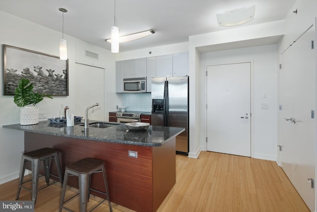 2101 Market St Unit 3405, Philadelphia, PA 19103 - kitchen featuring stainless steel appliances, a sink, a peninsula, a kitchen breakfast bar, and light wood-type flooring