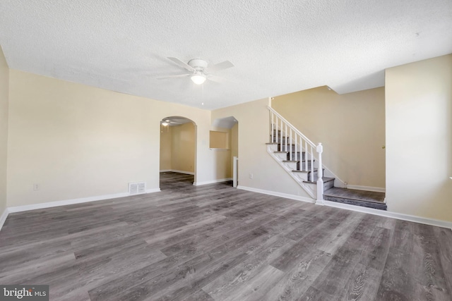 415 Arlington Ave, Upper Darby, PA 19082 - unfurnished living room with ceiling fan, arched walkways, wood finished floors, a textured ceiling, and stairs