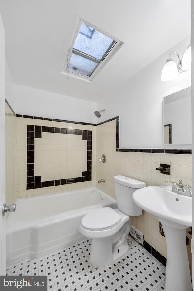 415 Arlington Ave, Upper Darby, PA 19082 - full bathroom featuring a skylight, toilet, shower / washtub combination, tile walls, and tile patterned flooring