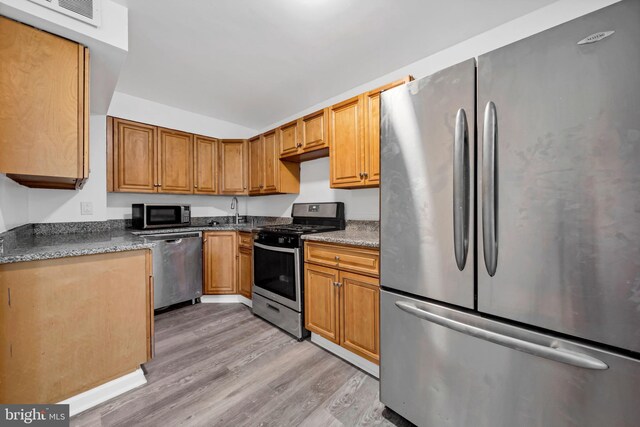 415 Arlington Ave, Upper Darby, PA 19082 - kitchen featuring stainless steel appliances, light wood-style flooring, a sink, brown cabinets, and lofted ceiling