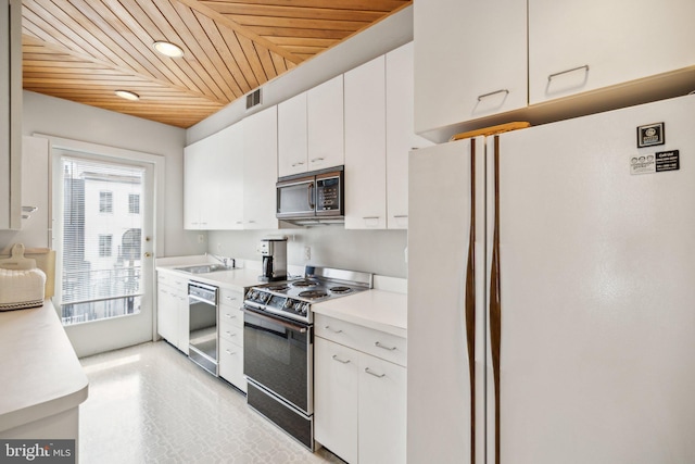 kitchen with stainless steel appliances, wood ceiling, a sink, white cabinetry, and light countertops