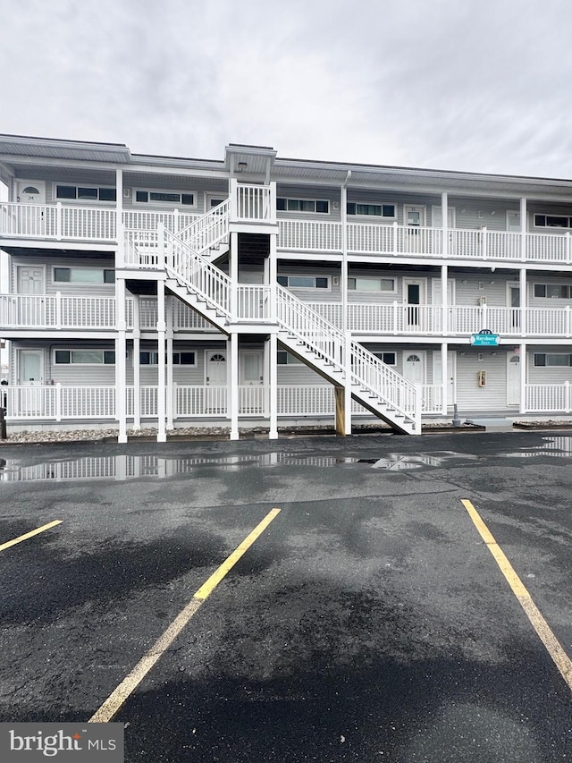 view of building exterior featuring uncovered parking and stairway