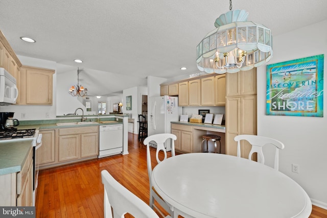 dining area featuring a chandelier, light wood-style floors, recessed lighting, and a textured ceiling