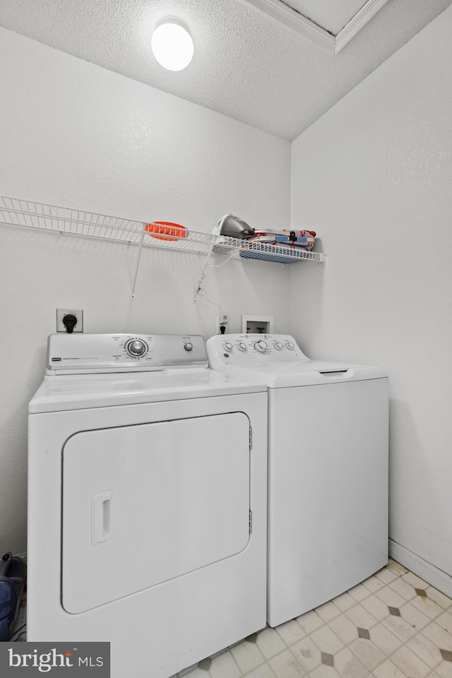 laundry room featuring separate washer and dryer, a textured ceiling, and light flooring