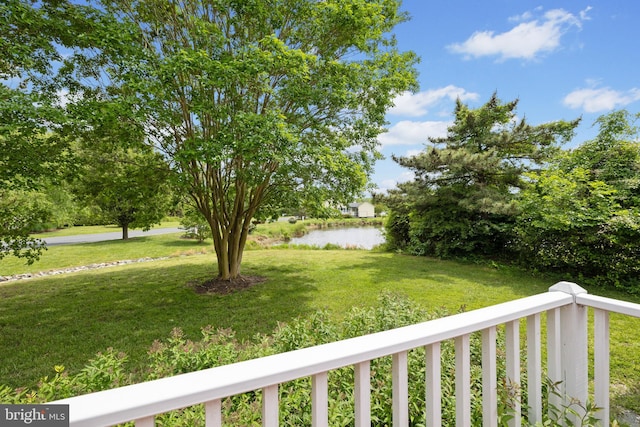 view of green lawn with a water view