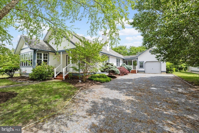 single story home featuring a garage, gravel driveway, covered porch, and a chimney