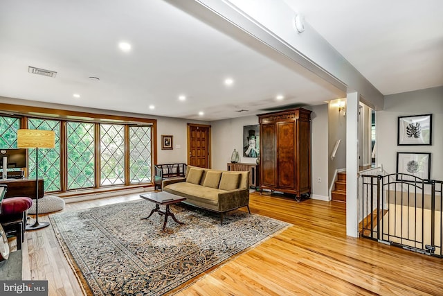 living room with light wood-style flooring, recessed lighting, baseboards, and stairway
