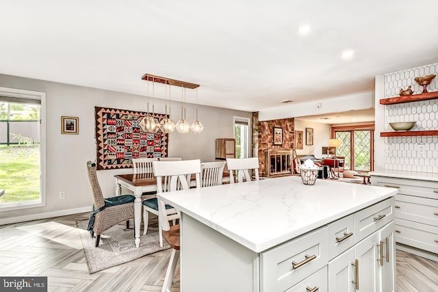 kitchen featuring open shelves, a kitchen island, hanging light fixtures, baseboards, and recessed lighting