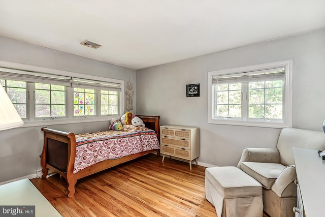 bedroom featuring baseboards and light wood finished floors