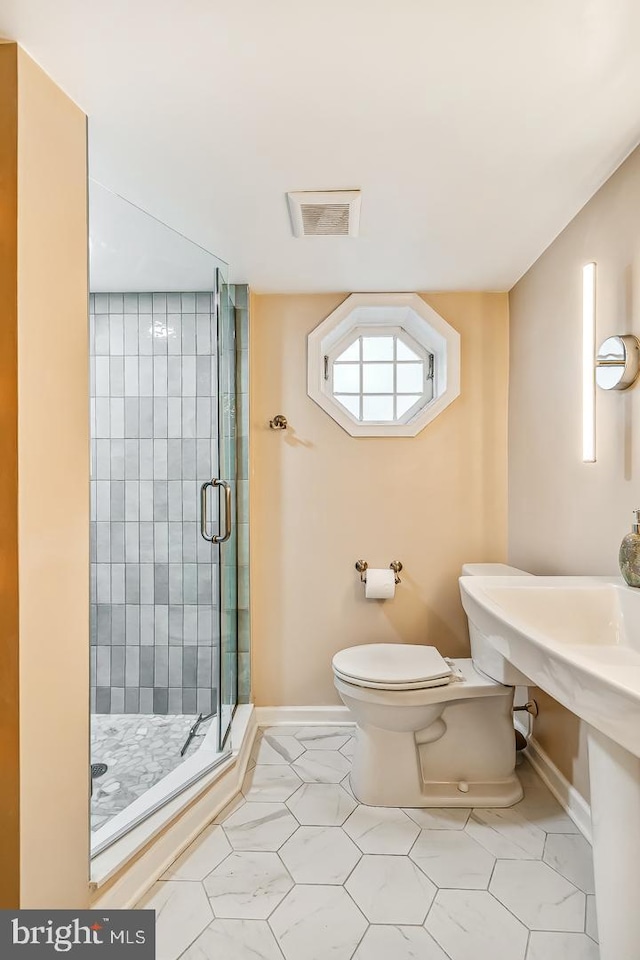 bathroom featuring a stall shower, toilet, baseboards, and tile patterned floors