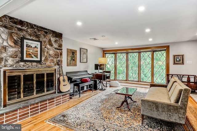 living room featuring wood finished floors, a fireplace, and recessed lighting