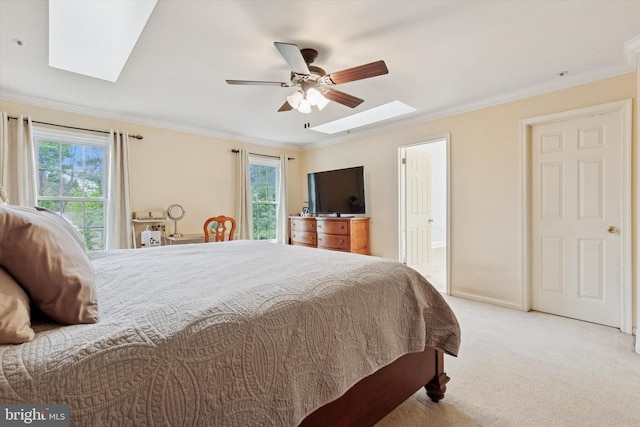 carpeted bedroom with a skylight, crown molding, a ceiling fan, and ensuite bathroom