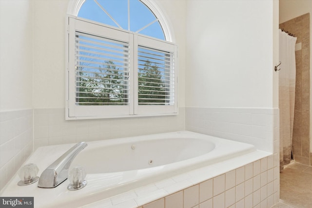 full bath with a garden tub and tile patterned flooring