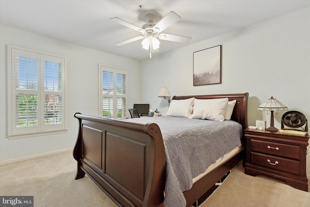 bedroom with light colored carpet, baseboards, and ceiling fan