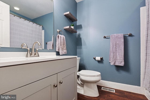 full bathroom with wood finished floors, toilet, baseboards, and vanity