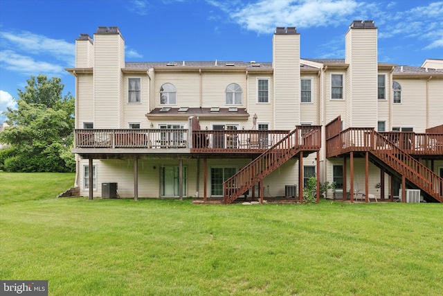 back of house featuring stairs, a wooden deck, a chimney, and a yard