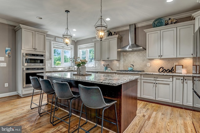 6034 Franconia Rd, Alexandria, VA 22310 - kitchen featuring wall chimney range hood, a center island, a kitchen breakfast bar, light stone counters, and crown molding