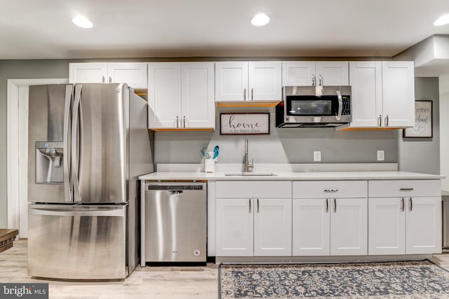 6034 Franconia Rd, Alexandria, VA 22310 - kitchen with stainless steel appliances, a sink, white cabinets, light countertops, and light wood-style floors