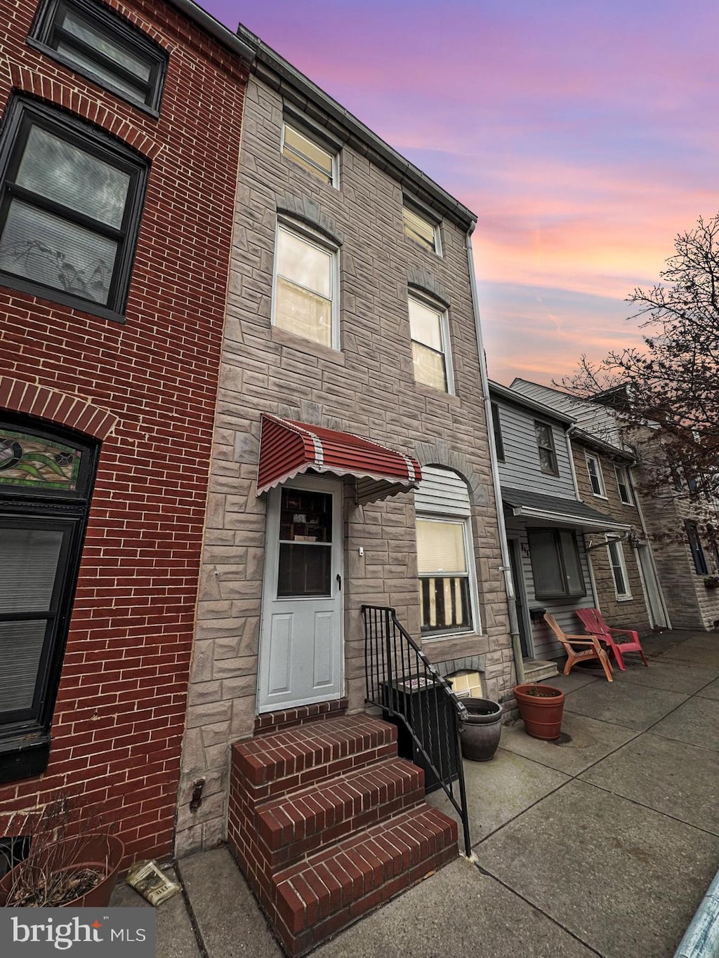 townhome / multi-family property featuring stone siding